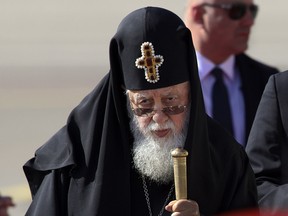 FILE - In this Friday, Sept. 30, 2016 file photo, Georgian Orthodox Patriarch Ilia II listens to the national anthem during a welcoming ceremony for Pope Francis in Tbilisi, Georgia