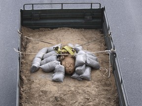 A military truck carries an unexploded World War II bomb