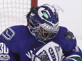 Vancouver Canucks goaltender Ryan Miller's mask is knocked off by a shot from the Calgary Flames on Feb. 18.
