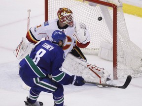 Vancouver Canucks defenceman Chris Tanev scores the game-winning goal against Calgary Flames goalie Brian Elliott in overtime on Feb. 18.
