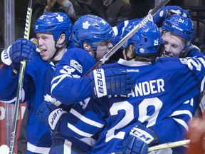 Jake Gardiner, right, is mobbed by Maple Leafs teammates after scoring the game winning goal in overtime against the Winnipeg Jets in Toronto on Tuesday night.
