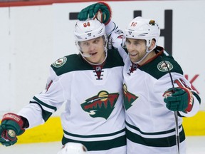 Mikael Granlund, left, celebrates scoring his third goal with Minnesota Wild teammate Jason Zucker during third period action against the Canucks in Vancouver on Saturday night.