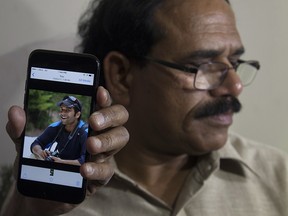 A man shows a picture of Alok Madasani, an engineer who was injured in the shooting Wednesday night in a crowded suburban Kansas City bar, on a mobile phone as Madasani's father Jaganmohan Reddy talks to the media at his residence in Hyderabad, India, Friday, Feb. 24, 2017.