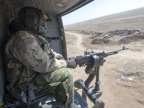 A Canadian Forces door gunner keeps watch as his Griffon helicopter goes on a mission, Feb. 20, 2017 in northern Iraq.