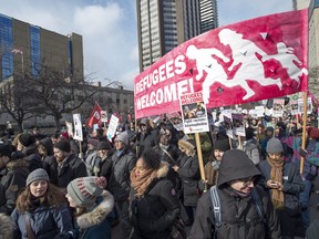 Demonstrators protesting the U.S. Muslim immigration ban march in front of the U.S. consulate in Toronto on Saturday Feb. 4. Some at the rally called on Prime Minister Justin Trudeau to do more for refugees stuck in limbo thanks to the ban.