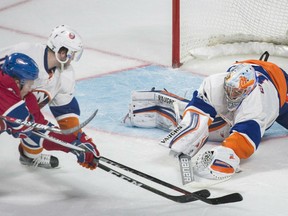 New York Islanders' goaltender Thomas Greiss comes out of the net to snare a loose puck during NHL action Thursday in Montreal. Trying to get his stick on the puck is Montreal's Artturi Lehkonen being defended by Isles' Alan Quine. Greiss had 24 saves in a 3-0 victory.