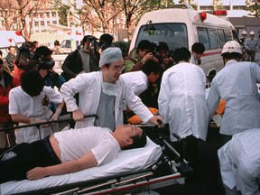 In this March 20, 1995 file photo, subway passengers affected by sarin nerve gas in the central Tokyo subway trains are carried into St. Luke's International Hospital in Tokyo. Doomsday cult Aum Shinrikyo dispersed sarin nerve gas on Tokyo subway trains and killed 13 people.