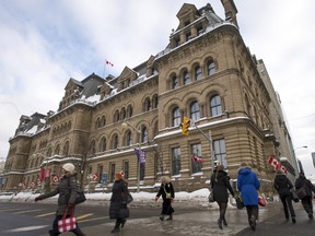 People walk past the Langevin Block on Thursday, Feb. 16, 2017 in Ottawa