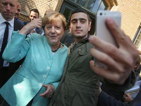 German Chancellor Angela Merkel poses for a selfie with a Syrian refugee Anas Modamani after she visited a shelter for migrants on Sept. 10, 2015 in Berlin, Germany. Modamani's selfie went viral for all the wrong reasons