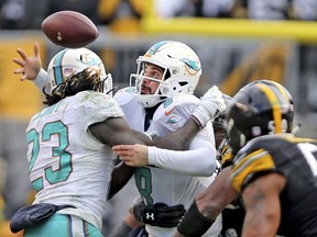 Miami Dolphins quarterback Matt Moore collides with Jay Ajayi as they play the Pittsburgh Steelers in the second half of an AFC wild-card NFL football game in Pittsburgh on Sunday, Jan. 8, 2017.