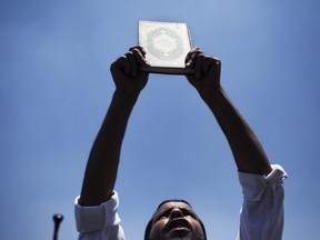 A man holds a Quran during a rally in Cairo University, in Giza, Egypt, Friday, July 5, 2013