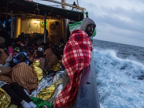Refugees and migrants are seen on deck of the Spanish NGO Proactiva Open Arms rescue vessel Golfo Azzurro sailing towards the Italian port of Pozzallo after being rescued off Libyan coast north of Sabratha on February 19, 2017.