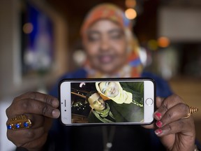 Saciido Shaie holds a picture of herself and close friend Mohamed Badal at a Somali restaurant in Minneapolis, Minn., on Thursday, Feb. 16, 2017. Badal left the United States last week and trekked through the snow covered border to get himself into Canada.