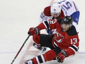 New Jersey Devils' Michael Cammalleri is dumped at centre ice by Montreal Canadiens' David Desharnais during NHL action Monday night in East Rutherford, N.J. The Canadiens were 4-3 winners in overtime.