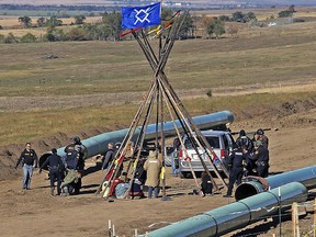 Law enforcement officers, left, drag away a person from a protest against the Dakota Access Pipeline on Oct. 10, 2016.