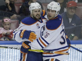 Kris Russell, left, celebrates with Oilers teammate Drake Caggiula after scoring against the Florida Panthers during the third period of their game Wednesday night in Sunrise, Fla. The Oilers won 4-3.