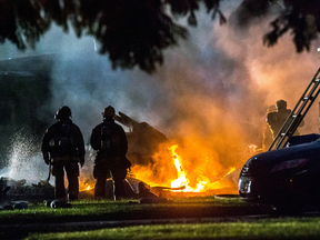 Firefighters put out flames after a plane crashed in Riverside, Calif., Monday, Feb. 27, 2017. The deadly crash injured several when a small plane collided with two homes Monday shortly after taking off from a nearby airport, officials said.