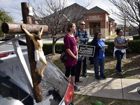 Anti-abortion supporters stand near a crucifix during opposing rallies outside of the Planned Parenthood South Dallas Surgical Health Services Center, Saturday morning, Feb. 11, 2017