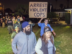 Protesters march towards the off-duty officer's home in Anaheim, Calif., Wednesday, Feb. 22, 2017. A Los Angeles policeman is under investigation after a video appears to show him firing a single round during an off-duty tussle with a 13-year-old boy. No one was injured but two teenagers were arrested after the incident, which spurred dozens of people to protest against police Wednesday night in the streets of Anaheim, where the officer lives and the confrontation occurred.
