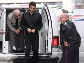 Kingston Police Const Jim Lindsay, right, watches as Mohammed Shafia, left, and his son Hamed arrive for court in Kingston on November 15 2011. On Thursday July 23 2015 Lindsay was charged by the Ontario Special Investigations unit with nine sex charges from complaints in the 1980's