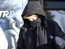 Martina Cain covers her face as she leaves the Saskatchewan Professional Teachers Regulatory Board office in Regina