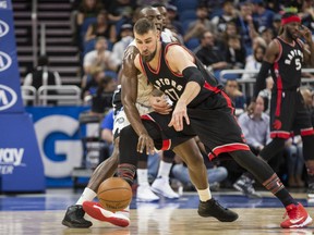 Toronto Raptors centre Jonas Valanciunas and the Magic's Bismack Biyombo fight for a loose ball during the first half of their game in Orlando, Fla., on Friday night.