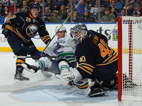 Alexandre Burrows of the Vancouver Canucks wreaks havoc in front of Buffalo Sabres' goaltender Robin Lehner during NHL action Sunday in Buffalo. Sabres defenceman Jake McCabe does his bit to trip up Burrows,who played a leading role in Vancouver's 4-2 victory.