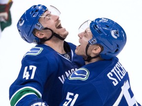 The Vancouver Canucks' Troy Stecher, right,  celebrates Sven Baertschi's second goal against the Minnesota Wild on Nov. 29, 2016. Stecher is the Canucks' only confirmed case of the mumps currently.