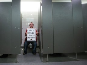 Marlena Boyle protests a lack of gender inclusive washrooms in a men's washroom at Simon Fraser University in Burnaby, B.C., on Wednesday February 18, 2015.