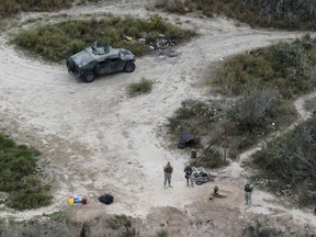 In this Feb. 24, 2015, file photo, members of the National Guard patrol along the Rio Grande at the Texas-Mexico border in Rio Grande City, Texas.