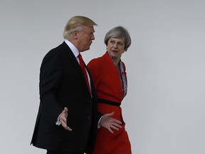 In this file photo dated Friday, Jan. 27, 2017, US President Donald Trump and Britain's Prime Minister Theresa May walk along the colonnades of the White House in Washington.  British lawmakers are set to hold a debate on Monday in London to consider a call for U.S. President Donald Trump to be denied an official state visit to the U.K., but the Conservative government insists the invitation remains firmly in place.