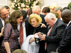 In this 2012 photo provided by a former member of the church, Word of Faith Fellowship leader Jane Whaley, centre, holds a baby, accompanied by her husband, Sam, centre right, and others during a ceremony in the church's compound in Spindale, N.C.