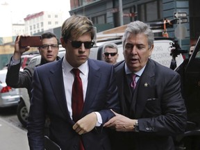 Milo Yiannopoulos, foreground left, arrives for a news conference in New York, Tuesday, Feb. 21, 2017. The technology editor at Breitbart News came under fire from other conservatives after a video emerged showing him making comments on sexual relationships between boys and older men.