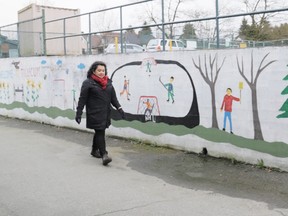 : Gloria Roque walks past a mural at Tillicum Annex, an East Vancouver school with about 90 students. Roque says the school system is much different than when she started teaching 17 years ago.