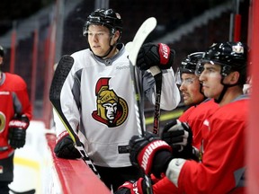 Curtis Lazar (left), whom the Ottawa Senators traded at the deadline, stands behind the bench in practice along with new acquisition Alex Burrows (far right) on March 1.