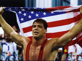 Kurt Angle of the United States holds the American flag at the free-style wrestling competition during the Summer Olympics at the Georgia World Congress Center in Atlanta, Georgia.