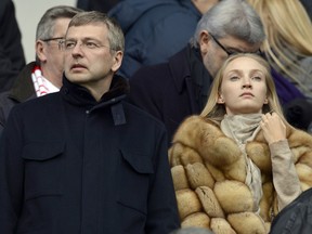 This file picture dated March 1, 2014  shows Dmitri Rybolovlev (L) attending the French L1 football match with an unidentified fur-clad woman.
