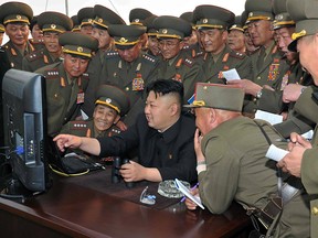North Korean leader Kim Jong-Un, cen looking at a computer as he inspects a shelling drill of a long-range artillery sub-unit tasked to hit major targets in the southwestern waters at undisclosed place in North Korea.