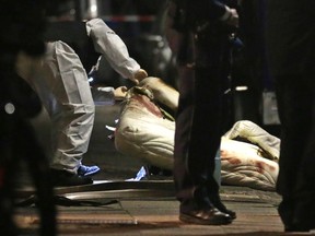 Forensic experts examine a mattress on March 9, 2017, in front of a house in Herne, Germany, close to where a 19-year-old man suspected of stabbing a nine-year-old boy to death was arrested.