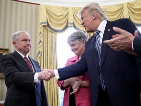 U.S. President Donald Trump (2nd R) shakes the hand of  Jeff Sessions after Sessions was sworn in as the new U.S. Attorney General by U.S. Vice President Mike Pence (R) in the Oval Office of the White House February 9, 2017 in Washington, DC. Trump also signed three executive orders immediately after the swearing in ceremony. Also pictured is Sessions's wife, Mary (2nd L), holding the bible.