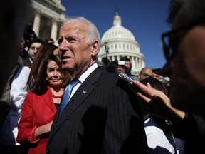 Former U.S. Vice President Joseph Biden speaks to members of the media as House Minority Leader Rep. Nancy Pelosi looks on after an event on health care on March 22 in Washington.