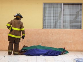 A firefighter looks at the corpses of two of the 20 victims of a fire at children's shelter in San Jose Pinula, about 10 kilometres east of Guatemala City, on March 8, 2017.