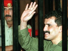 Jordanian soldier Ahmed Daqamseh  waves to his family on June 25, 1997 from behind  bars, during his hearing at a Amman military court.