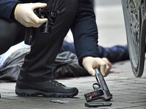 An Ukrainian police expert seizes a gun at the scene where former Russian MP Denis Voronenkov was shot dead on March 23, 2017 in the center of Kiev.