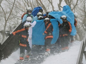 Firefighters carry a survivor they rescued from the site of an avalanche in Nasu town, Tochigi prefecture on March 27, 2017. Eight high school students were feared dead on March 27 after being engulfed by an avalanche while on a mountain-climbing outing with dozens of others, officials said.