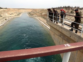 Members of the U.S.-backed Syrian Democratic Forces (SDF), made up of an alliance of Arab and Kurdish fighters, inspect the Tabqa dam on March 27, 2017, which has been recently partially recaptured, as part of their battle for the jihadists' stronghold in nearby Raqa.