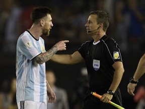 Argentina's forward Lionel Messi (L) argues with first assistant referee Emerson Augusto de Carvalho at the end of their 2018 FIFA World Cup Russia South American qualifier football match against Chile, at the Monumental stadium in Buenos Aires, on March 23, 2017.