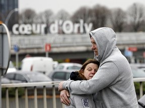 Travellers hug outside Orly airport, south of Paris, Saturday, March, 18, 2017. A man was shot to death Saturday after trying to seize the weapon of a soldier guarding Paris' Orly Airport, prompting a partial evacuation of the terminal, police said.