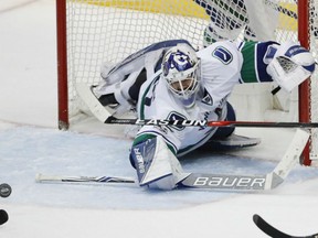 Goaltender Richard Bachman of the Vancouver Canucks shows his athleticism as he knocks down a loose puck in front of his goal during NHL action Sunday in Anaheim. Bachman won his first game since October of 2015 with 43 saves in a 2-1 victory over the Anaheim Ducks.