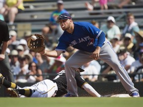 Pittsburgh Pirates second baseman Josh Harrison slides safely back to first base as Toronto Blue Jays first baseman Rowdy Tellez receives a throw-over during fourth inning of a Grapefruit League spring training game in Bradenton, Fla., on Feb. 28, 2017.